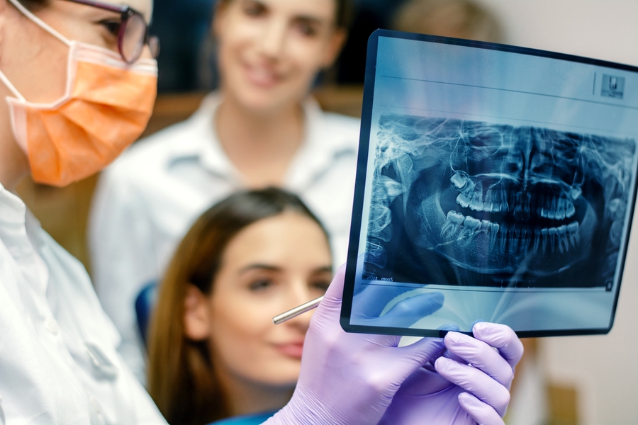Tandläkare och pratient titta på röntgenbilder